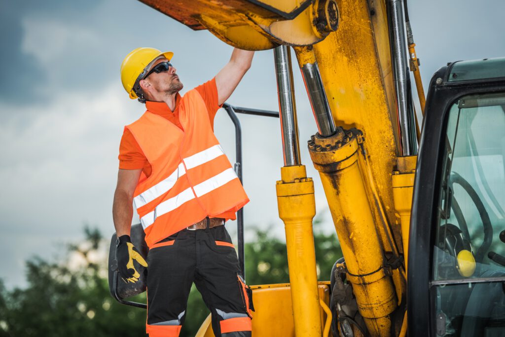 operator sprawdzający stan koparki przed rozpoczęciem pracy